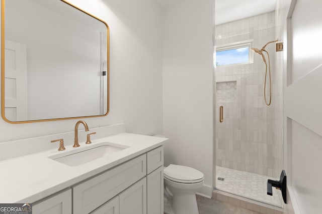 bathroom featuring tile patterned floors, vanity, toilet, and a shower with door