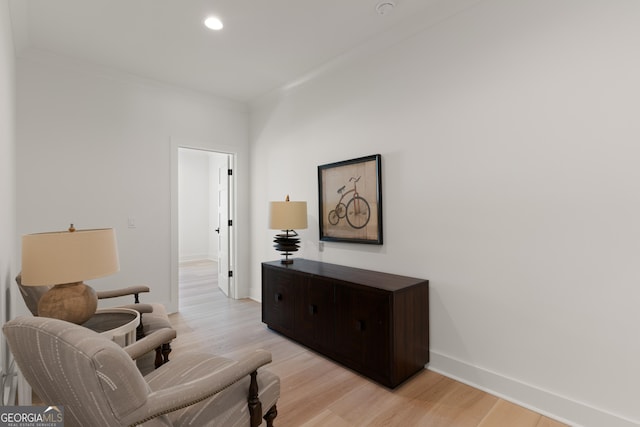 sitting room featuring crown molding and light wood-type flooring