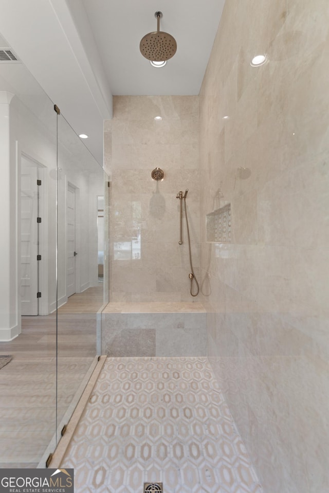 bathroom featuring tile patterned flooring and a tile shower