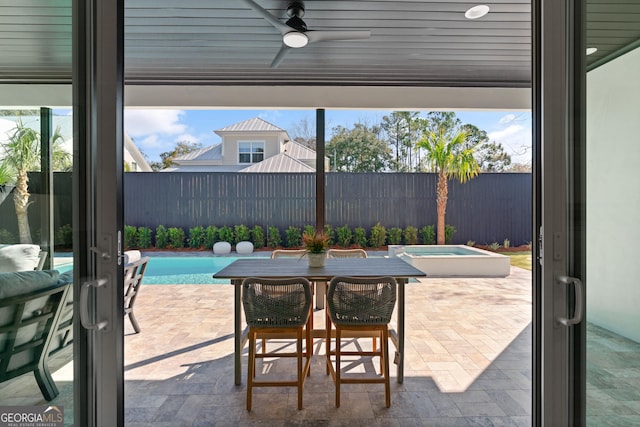 view of patio with ceiling fan and a pool with hot tub