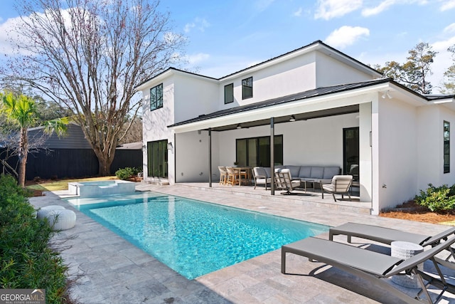 back of property featuring a swimming pool with hot tub, outdoor lounge area, a patio, and ceiling fan