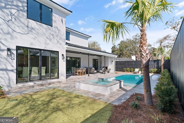 back of house featuring a pool with hot tub, a yard, a patio, and ceiling fan