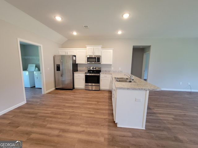 kitchen featuring white cabinetry, appliances with stainless steel finishes, light hardwood / wood-style floors, and washing machine and dryer