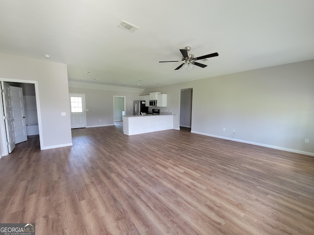 unfurnished living room with ceiling fan and light wood-type flooring