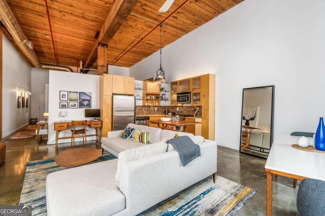 living room with wooden ceiling, beam ceiling, and a high ceiling