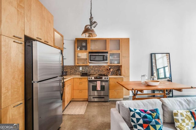 kitchen with tasteful backsplash, stainless steel appliances, light brown cabinetry, and hanging light fixtures