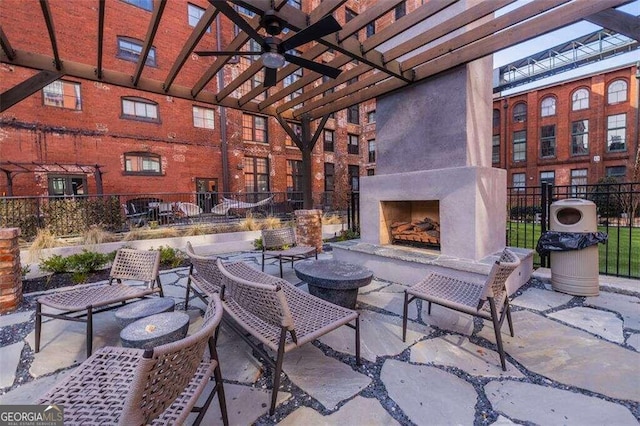 view of patio with ceiling fan, exterior fireplace, and a pergola