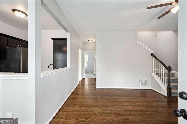 unfurnished living room featuring dark hardwood / wood-style floors and ceiling fan