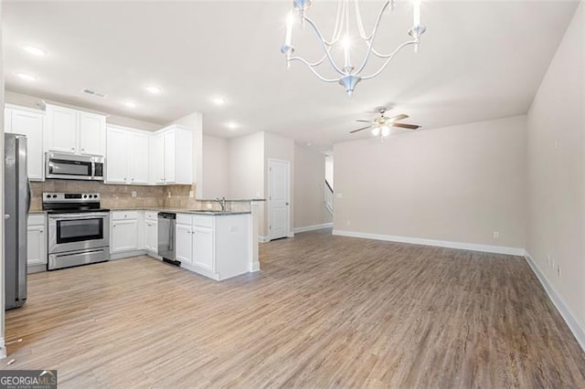 kitchen featuring white cabinetry, stainless steel appliances, tasteful backsplash, and light hardwood / wood-style flooring