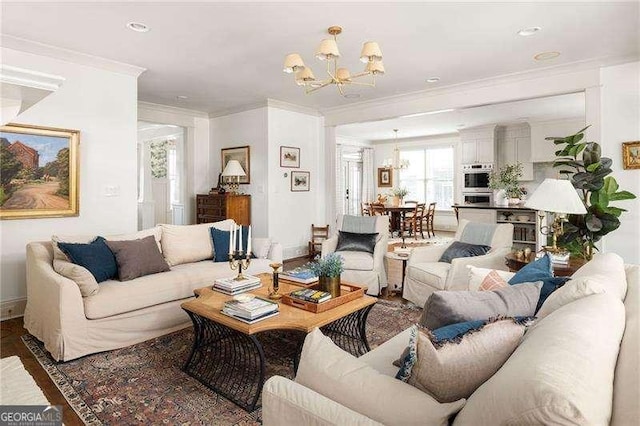 living room featuring crown molding, dark wood-type flooring, and a notable chandelier