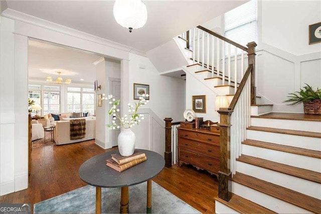 stairs featuring hardwood / wood-style flooring and ornamental molding