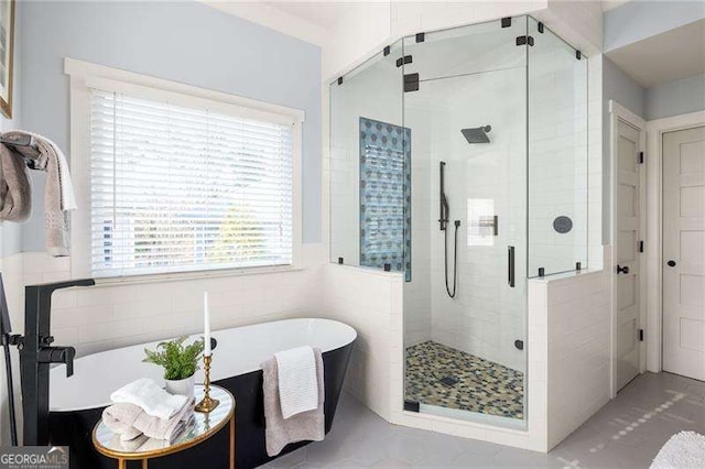 bathroom featuring tile walls and plus walk in shower