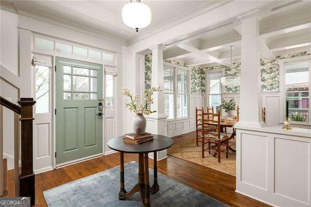 foyer entrance featuring dark hardwood / wood-style floors, plenty of natural light, coffered ceiling, and decorative columns