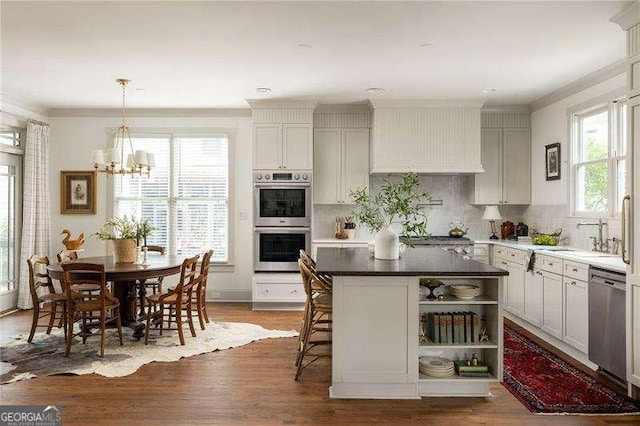 kitchen featuring a kitchen island, appliances with stainless steel finishes, sink, a breakfast bar area, and backsplash