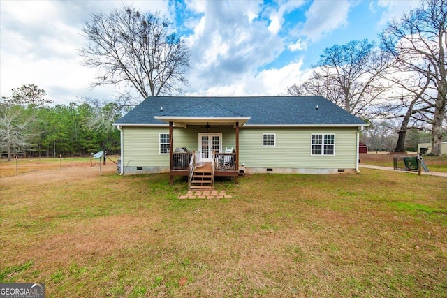 rear view of property with a lawn and a deck