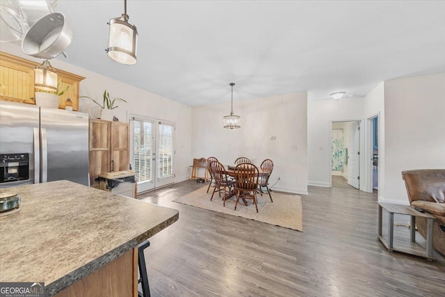 kitchen with french doors, dark hardwood / wood-style floors, pendant lighting, and stainless steel fridge with ice dispenser