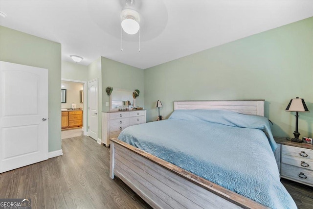 bedroom with connected bathroom, hardwood / wood-style flooring, and ceiling fan