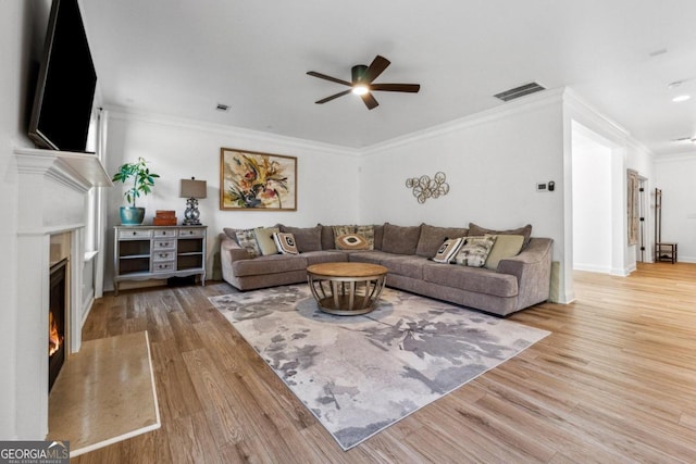 living room featuring ornamental molding, hardwood / wood-style floors, and ceiling fan