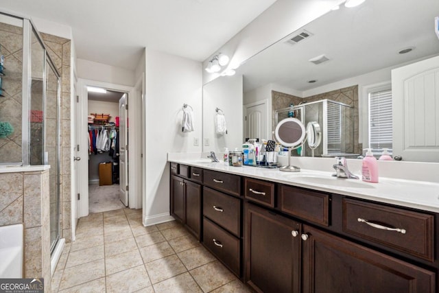 bathroom with an enclosed shower, vanity, and tile patterned floors