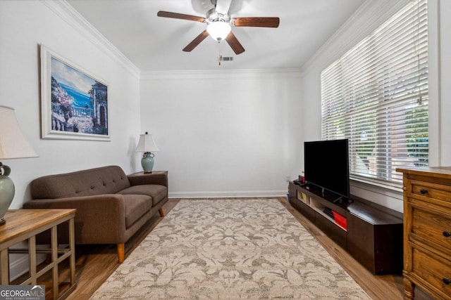 living room featuring crown molding, ceiling fan, and light hardwood / wood-style floors