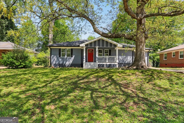 single story home featuring a front lawn and covered porch