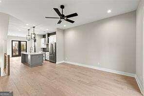 unfurnished living room featuring ceiling fan and light hardwood / wood-style flooring