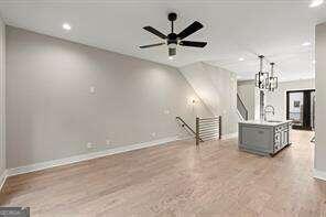 unfurnished living room with ceiling fan and light wood-type flooring