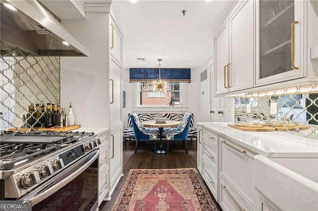 kitchen with stainless steel range with gas cooktop, decorative light fixtures, white cabinets, custom exhaust hood, and light stone countertops