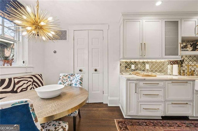 dining space featuring an inviting chandelier and dark wood-type flooring