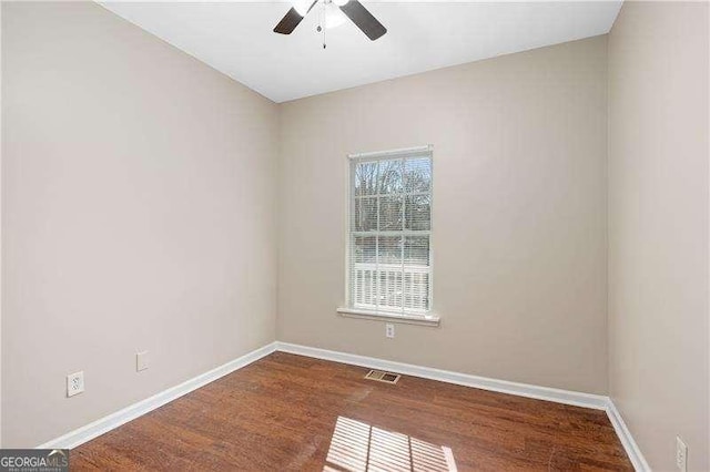 spare room featuring dark wood-type flooring and ceiling fan