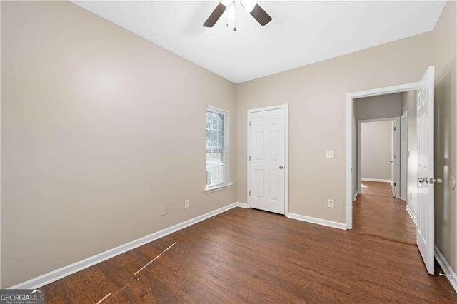 unfurnished bedroom with dark wood-type flooring and ceiling fan