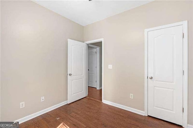 unfurnished bedroom with dark wood-type flooring