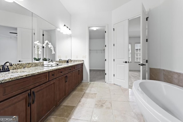 bathroom featuring tile patterned flooring, a bathtub, and vanity