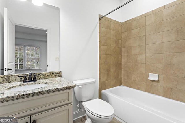 full bathroom featuring vanity, tiled shower / bath, and toilet