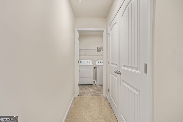 corridor featuring washing machine and dryer and light carpet