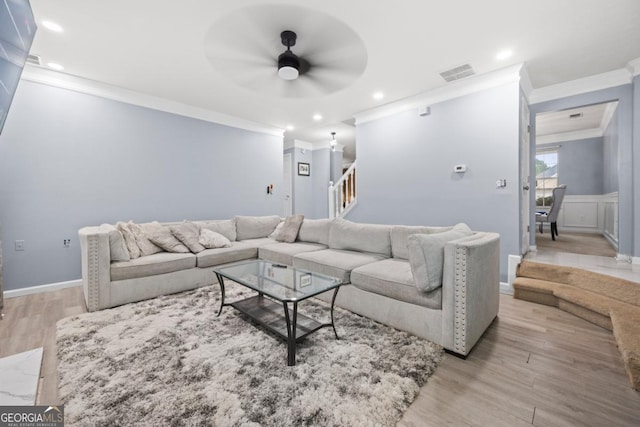 living room featuring crown molding, ceiling fan, and light hardwood / wood-style floors