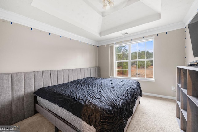 carpeted bedroom with ornamental molding and a raised ceiling