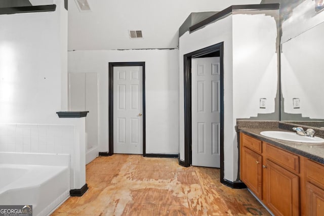 bathroom with vanity and a tub to relax in