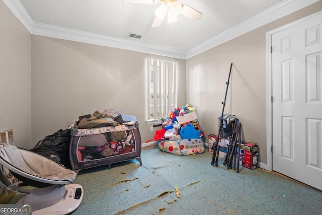 rec room featuring ceiling fan, ornamental molding, and carpet