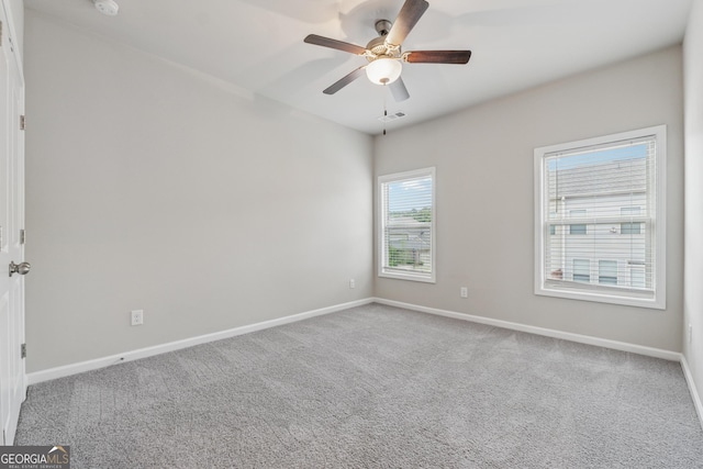 spare room with visible vents, carpet flooring, baseboards, and ceiling fan