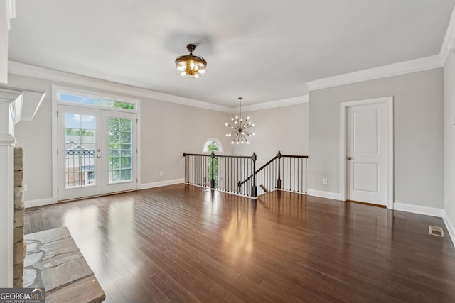 unfurnished room with baseboards, wood finished floors, a chandelier, and visible vents
