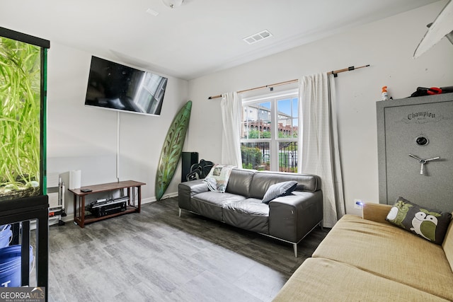 living area with visible vents and wood finished floors