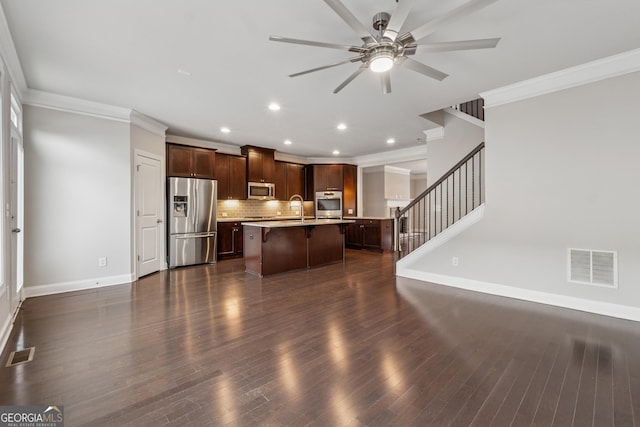 kitchen featuring visible vents, a sink, a kitchen bar, and appliances with stainless steel finishes