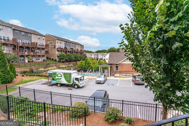 surrounding community featuring uncovered parking and fence