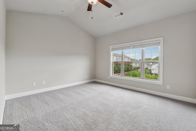 spare room with lofted ceiling, visible vents, carpet floors, baseboards, and ceiling fan