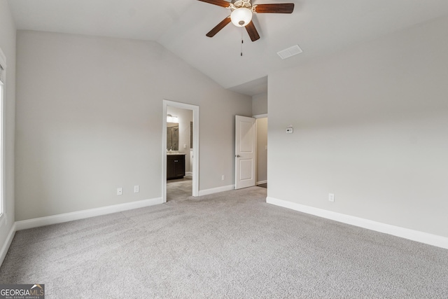 unfurnished bedroom featuring light carpet, vaulted ceiling, baseboards, visible vents, and ensuite bathroom