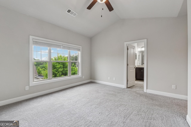 unfurnished bedroom with baseboards, lofted ceiling, visible vents, and light colored carpet