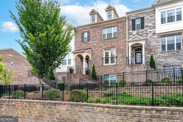 view of front facade with a fenced front yard and brick siding