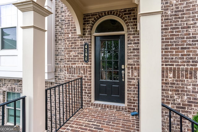 entrance to property featuring brick siding