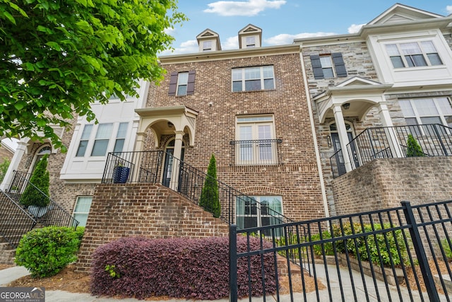 townhome / multi-family property with brick siding and fence